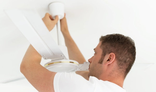 A technician inspecting the ceiling fan