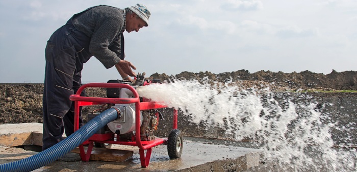 A worker using an industrial water pump