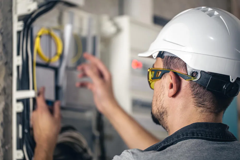 Man an electrical technician working in a switchboard with fuses_8_11zon