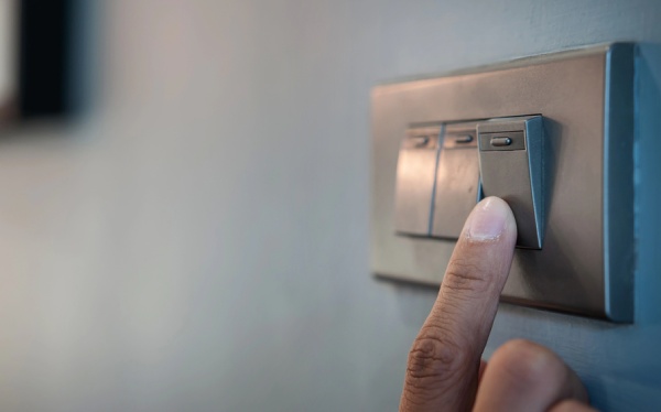 A person turning on a light switch