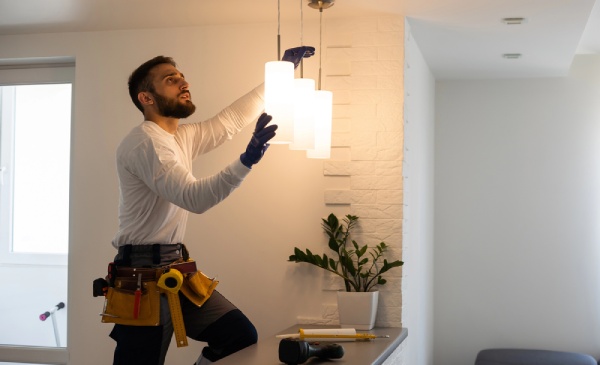 An electrician installing lamp lighting