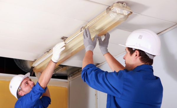 Two electricians installing a light