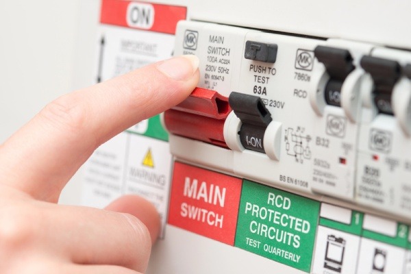 A person turning off an RCD switch